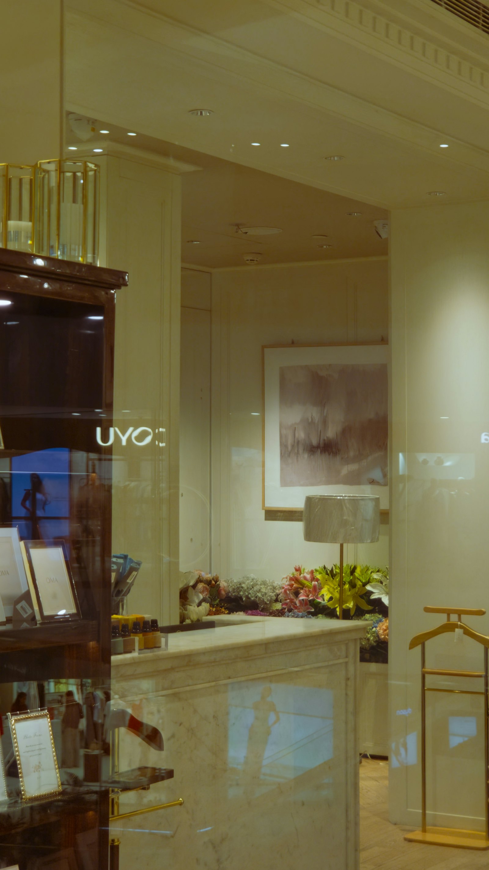 Boutique mit Empfangstheke aus Marmor, Blumen und Leuchte