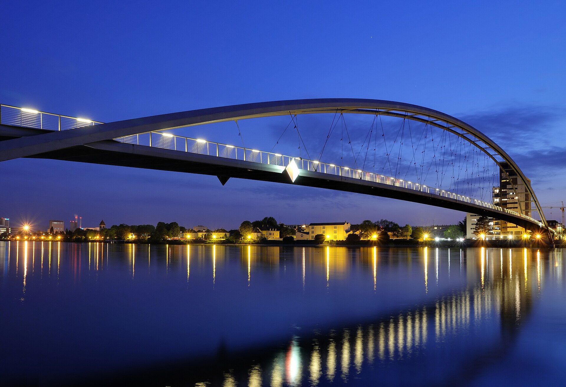 Die Dreiländerbrücke in Weil am Rhein bei Nacht, mit beleuchtetem Geländer über dem Rhein