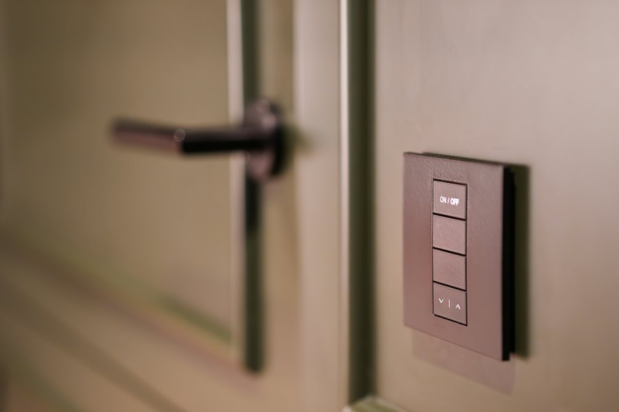 Smart-Home-Taster an einer Wand neben einer Tür